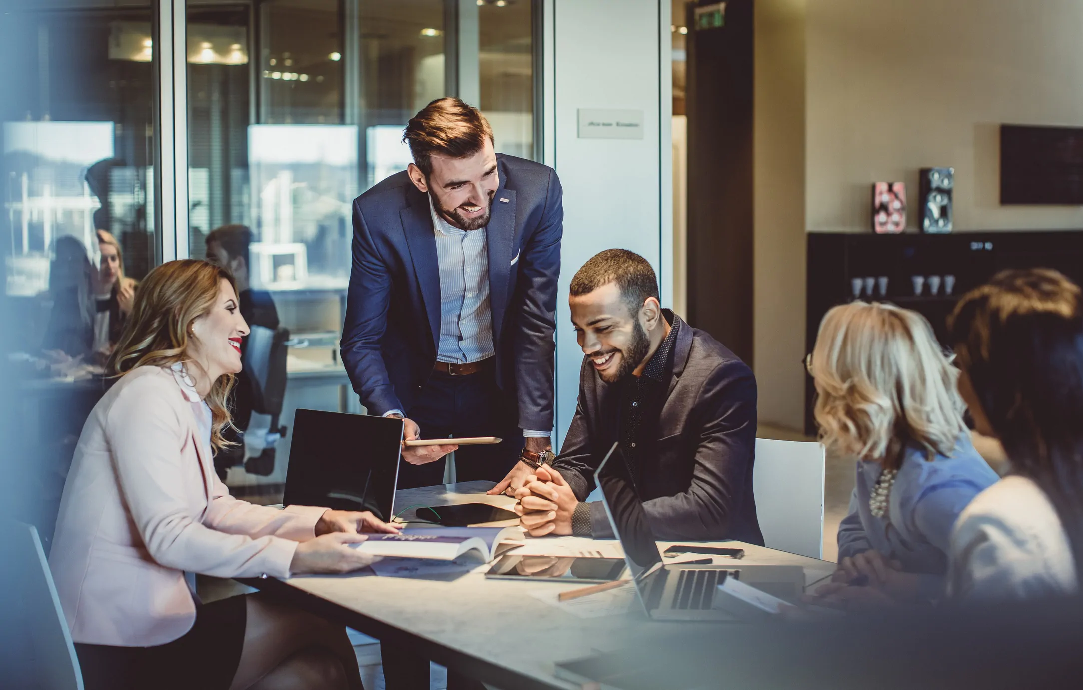 Sales Teams Gather Around Table to Discuss 2022 Sales Strategies